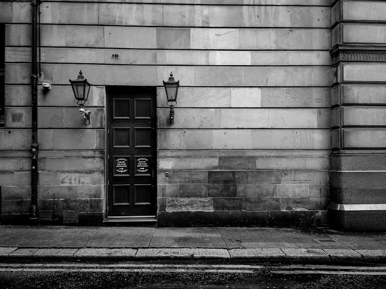 Black and white photo of a vintage stone building facade in Glasgow City, Scotland.