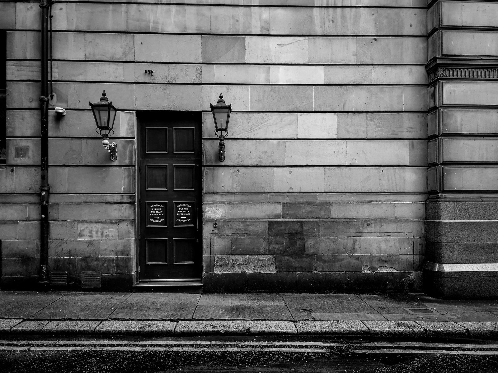 Black and white photo of a vintage stone building facade in Glasgow City, Scotland.