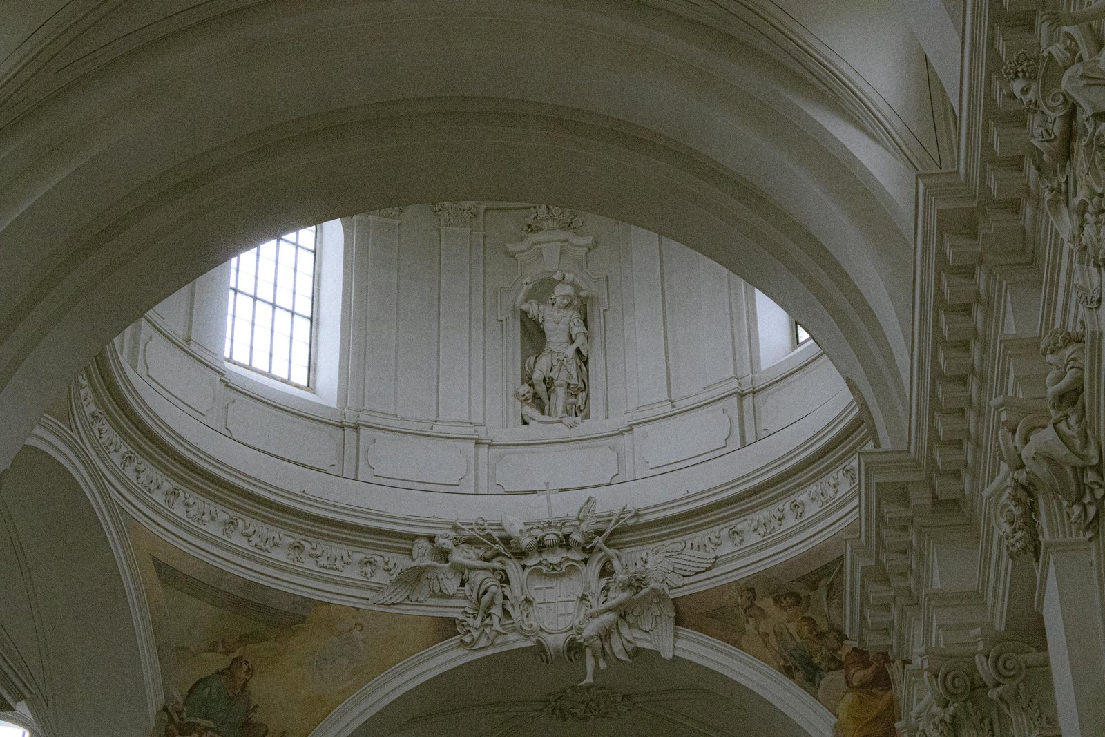 Elegant architecture of Fulda Cathedral's interior showcasing ornate white arches and religious art.