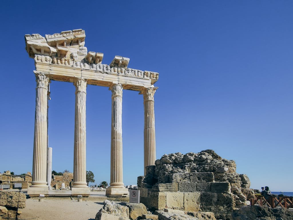 Stunning view of ancient Greek ruins with tall columns against a clear blue sky, perfect for travel inspiration.
