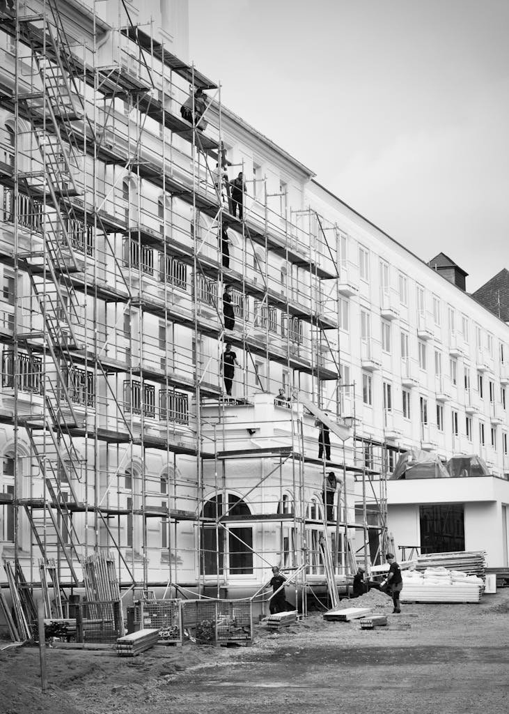Black and white photo of a historic building under renovation with scaffolding.